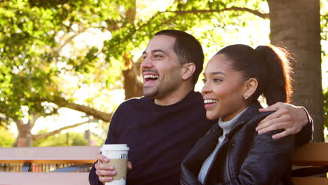 Young-Hispanic-couple-sitting-on-bench-in-park,-close-up