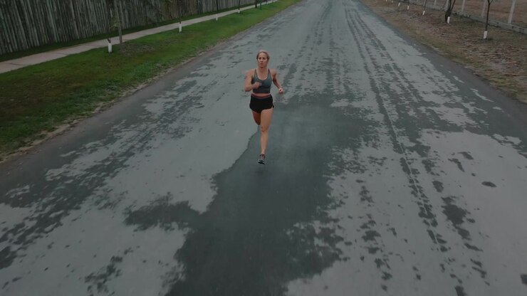 Giovane donna che fa jogging su una tranquilla strada di periferia