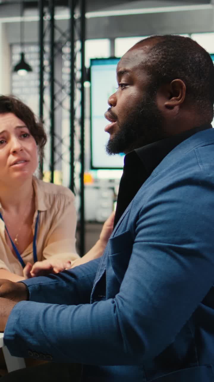 Vertical Video Exasperated black manager dealing with a stressful situation at the office