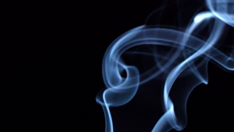 el humo azul sobre un fondo negro se mueve en espiral.