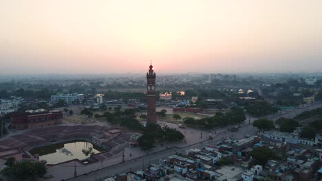 aerial shot of lucknow's historic clock tower at sunrise, with the sun rising behind the monument.