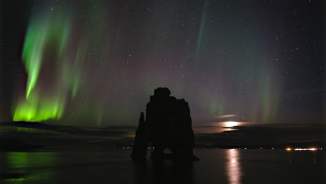 Lapso-De-Tiempo-De-La-Aurora-Boreal-Sobre-Hvítserkur,-Islandia-Con-Salida-De-La-Luna