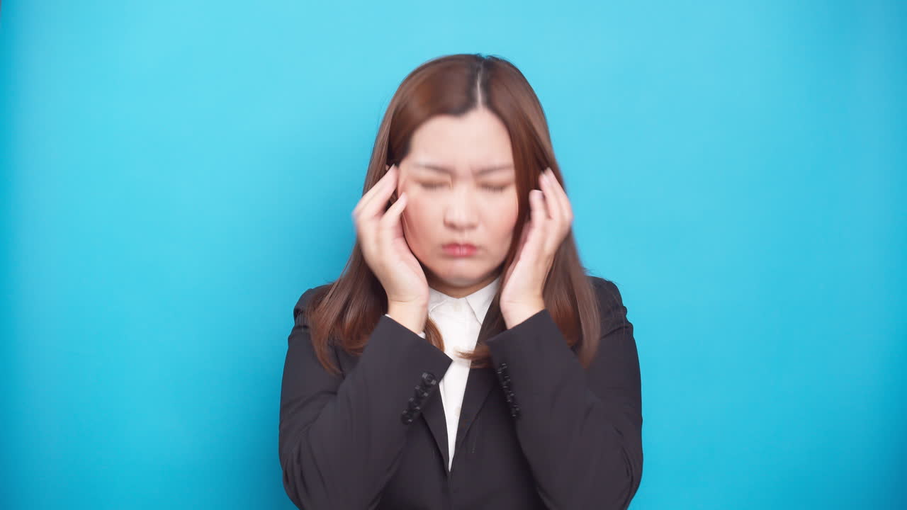 파란색 배경-1에 고립된 실망의 감정에 대처하는 좌절된 스트레스를 받은 젊은 아시아 여성 사업가