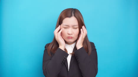 Frustrated-stressed-young-Asian-businesswoman-coping-with-emotions-of-disappointment-isolated-over-a-blue-background-1