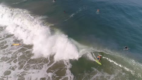 Toma-Aérea-De-Un-Surfista-Surfeando-Una-Gran-Ola-De-Tubo-Y-Cayendo-En-La-Playa-De-Zicatela-Puerto-Escondido,-Oaxaca