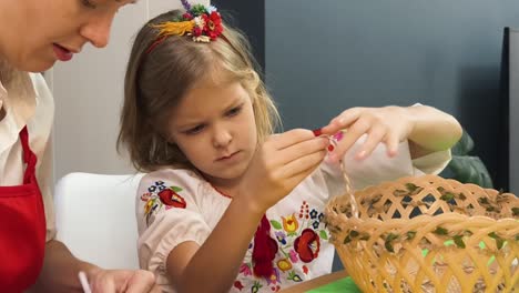 mother and daughter making a basket