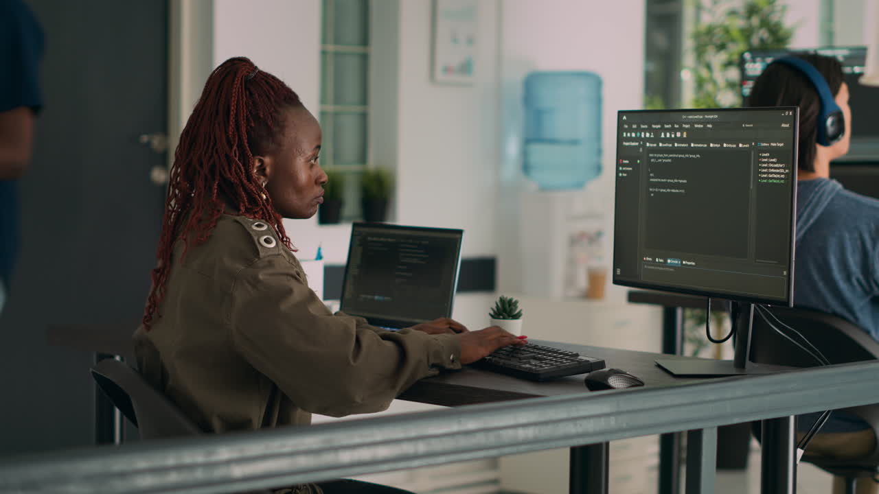 African american coder writing programming language on computer