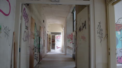 long corridor in a destroyed and abandoned building with a lot of graffiti