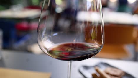 hand swirling red wine in a glass