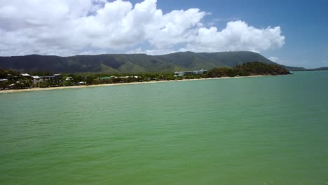 aerial over green waters off trinity beach with macalister range in the background