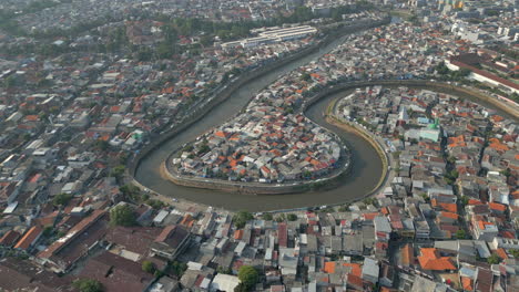 canal snakes around crowded slum neighborhoods in tebet jakarta drone rotate 4k 60fps