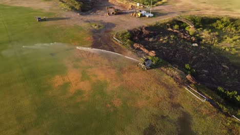 Orbit-Shot-Of-Sprinkler-Watering-Green-Grass-Of-San-Isidro-Racecourse,-Buenos-Aires,-Argentina