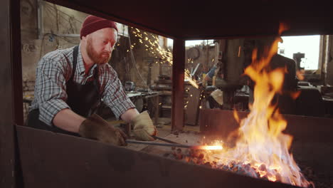 Blacksmith-Turing-Coal-and-Tending-Fire-in-Forge