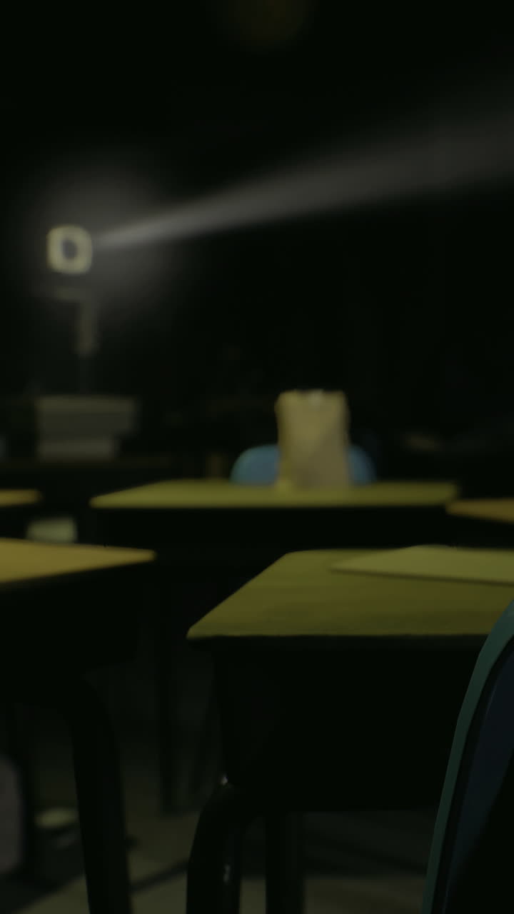Un'aula con banchi vuoti e un raggio di luce nel buio.