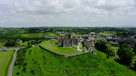 orbiting drone shot of the rock of cashel in ireland's rural countryside.
