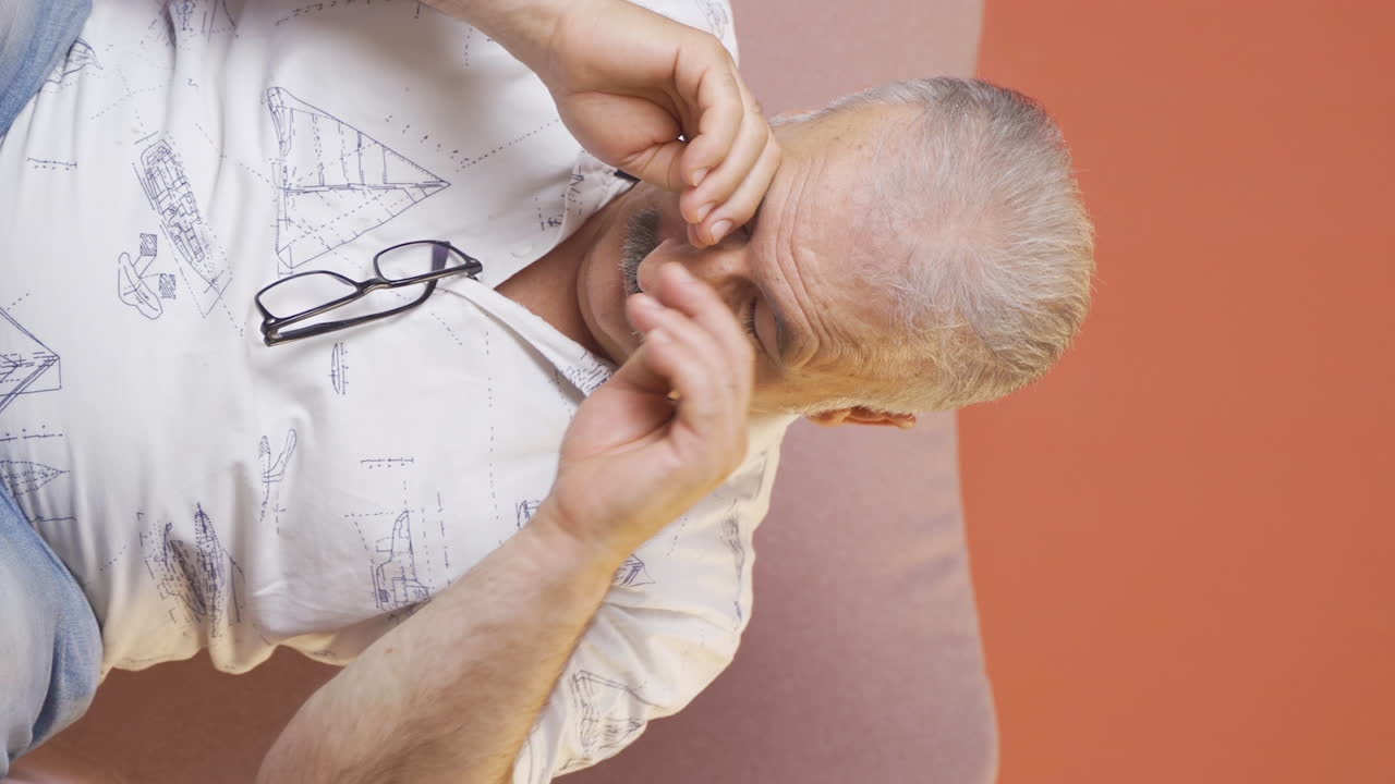 vídeo vertical de un anciano somnoliento bostezando.