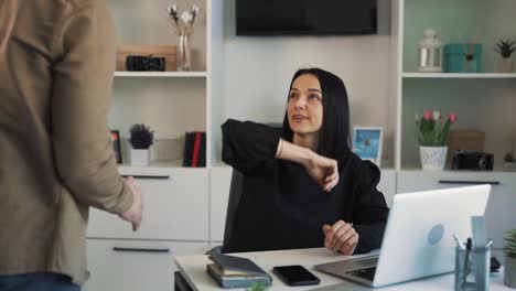 A-female-executive-is-sitting-with-a-laptop-in-her-office-when-her-subordinate-is-brought-to-her-to-talk-about-his-success