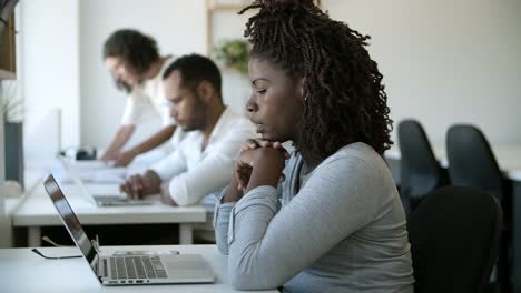 Traurige-Junge-Frau,-Die-Sich-Auf-Die-Hände-Stützt-Und-Auf-Den-Laptop-Schaut