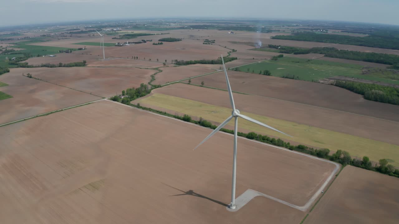 Wide aerial view of wind power machines spinning in the breeze