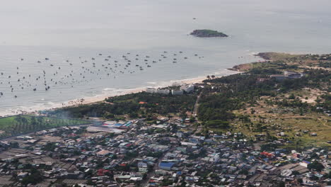 línea costera con barcos y la isla de hon lao en mui ne, vista aérea