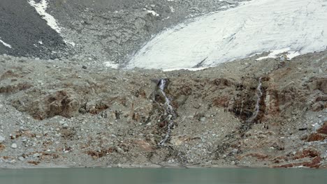 waterfall flowing from a melting glacier into a lake in patagonia. crystal clear water tumbles down from the ice, framed by rugged mountain terrain