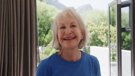 smiling senior woman enjoying sunny day at home with open windows