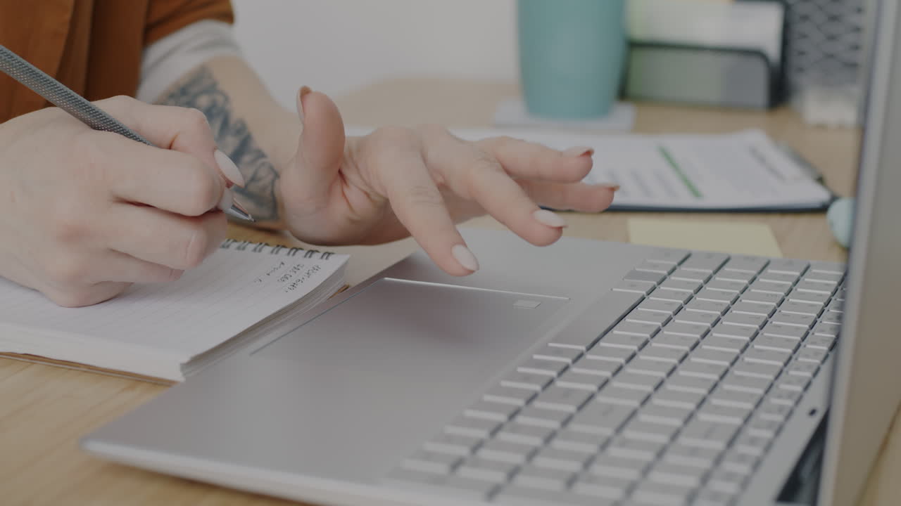 Woman working on laptop and taking notes