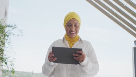 Happy-biracial-businesswoman-using-tablet-and-celebrating-at-office,-slow-motion