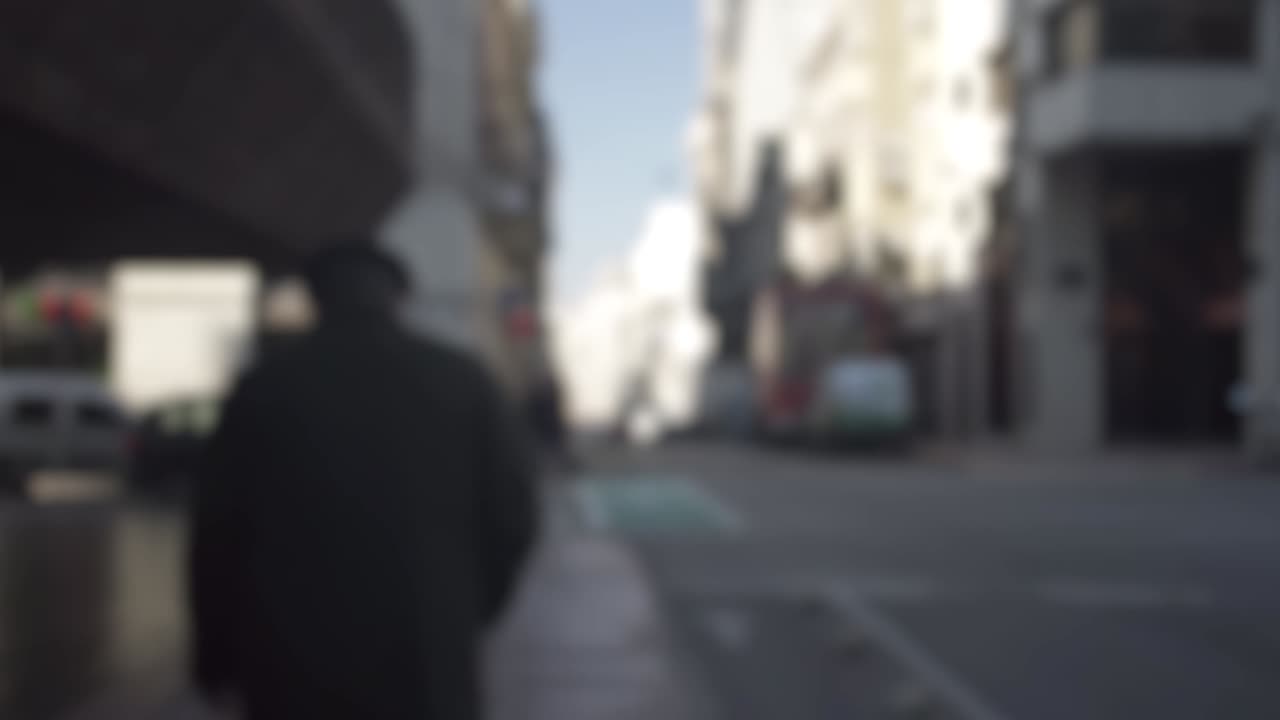 disparo de seguimiento borroso de un hombre caminando por las calles de montevideo