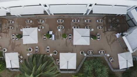 top view of tables and umbrellas in an empty hotel restaurant during pandemic
