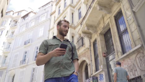 Young-man-is-walking-on-the-street-with-modern-houses.