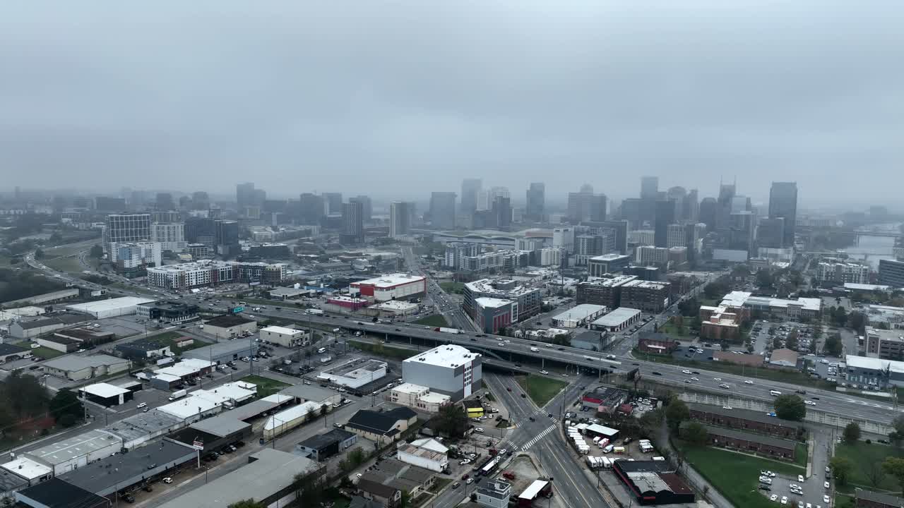 Drone footage orbiting downtown Nashville, Tennessee, from a distance, on a gloomy overcast day in the fall.