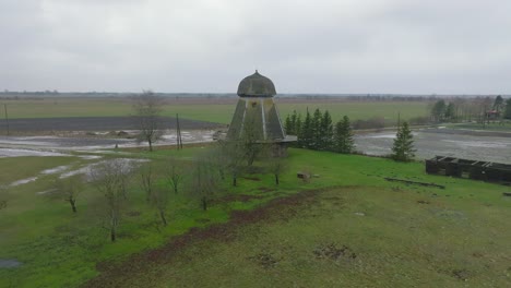 beautiful aerial establishing view of old wooden windmill in the middle of the field, prenclavu windmill , overcast winter day, wide ascending drone point of interest shot