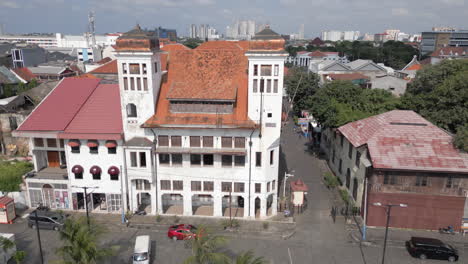 Drone-Wraps-Around-Old-Dutch-Mansion-On-The-Corner-In-Old-Batavia-With-Palm-Trees