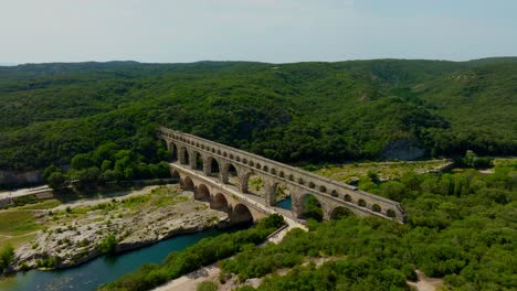 the majestic pont du gard in occitanie: a summer day amidst tourists enjoying bathing and canoeing