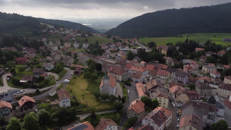 toma aérea giratoria sobre sainte croix, suiza en un día nublado