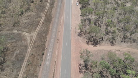 Toma-De-Drone-De-Carretera-Con-Ferrocarril-Al-Lado-Moviéndose-A-Un-Río,-Darwin,-Territorio-Del-Norte,-Australia