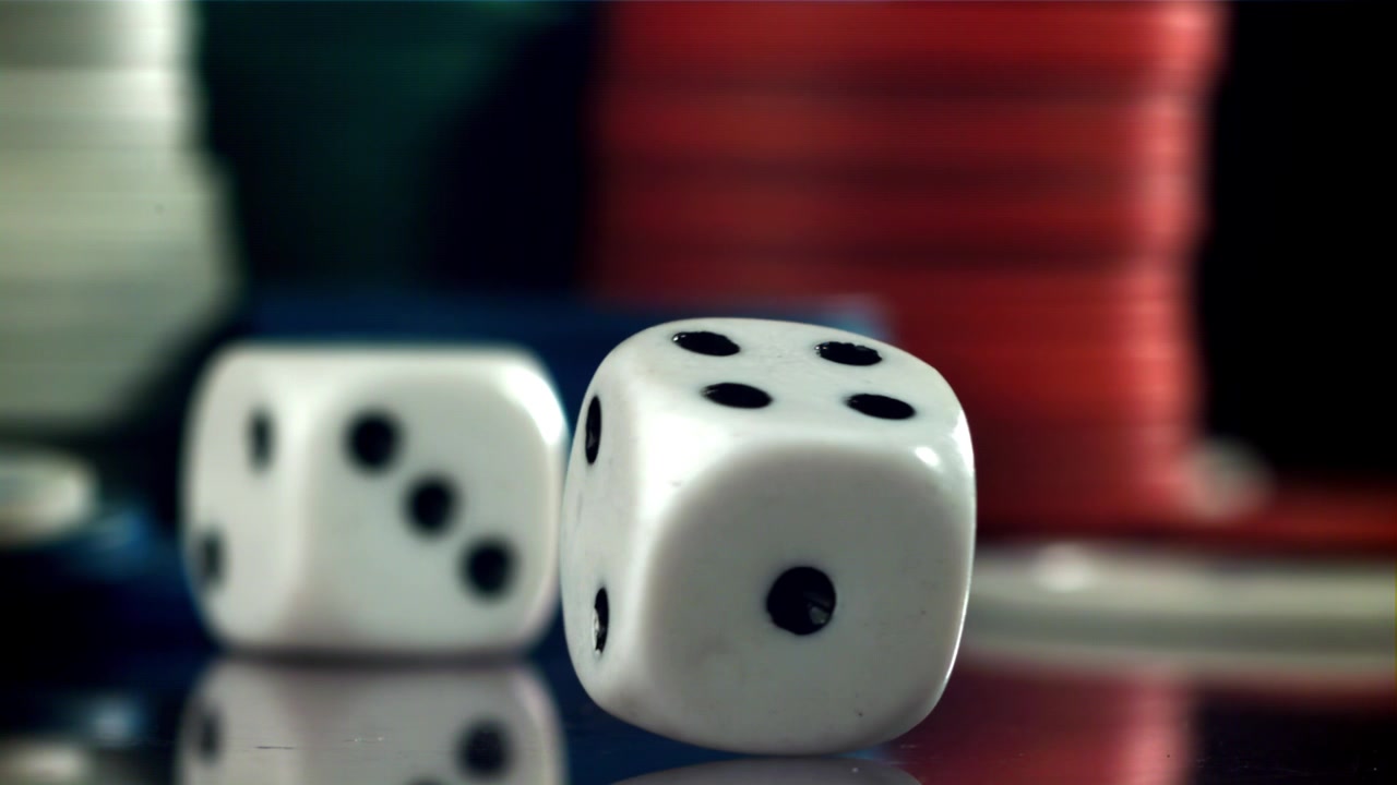 Dadi bianchi che cadono e girano al rallentatore con fiches da casinò