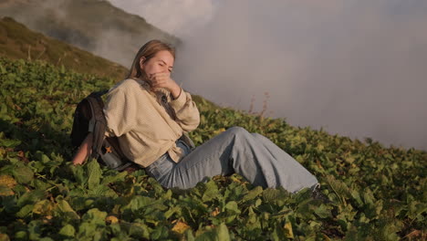 mujer relajándose en la cima de una montaña al atardecer