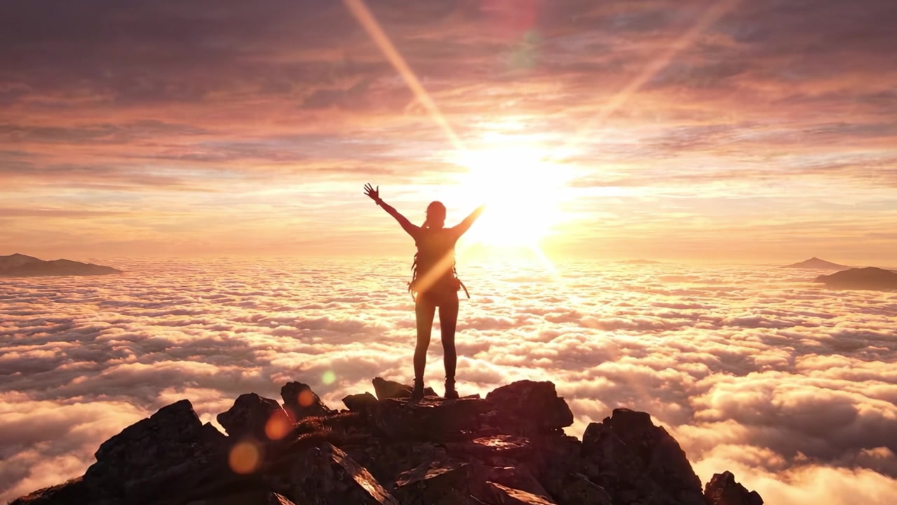 Un aventurero solitario se alza triunfante en una cima rocosa, silueteado contra un amanecer impresionante sobre un mar de nubes, encarnando el espíritu de libertad y exploración.