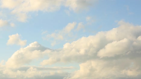 time lapse of thick and fluffy painterly clouds forming against a blue sky with turmoil of growing and diminishing blanket of clustering water droplets in the air making a dramatic cinematic scenery