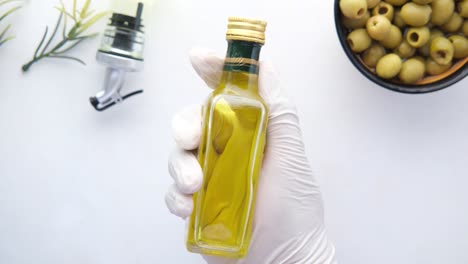 olive oil bottle in a white glove