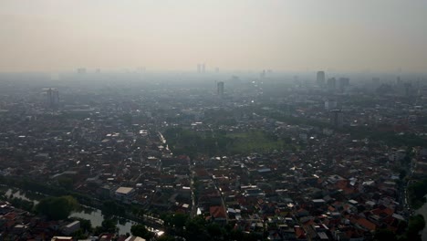 from above, surabaya's gray skies reveal the city's dense urban landscape and severe air pollution issues captured in aerial footage