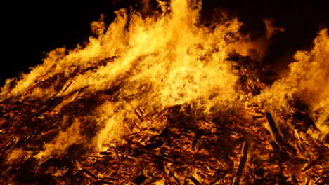 A-mid,-panning-shot-of-a-huge-bonfire-burning-in-slow-motion,-shot-in-180fps