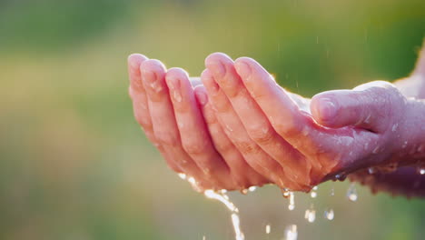 Ein-Mann-Hält-Seine-Hände-Im-Strömenden-Regen-Wassertropfen-Fliegen-Auseinander-Kühles-Und-Sauberes-Wasserkonzept-Langsam