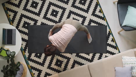 young woman doing stretching workout at home