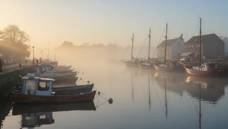 an enchanting morning at the misty harbor, where traditional boats gently rock in calm waters amidst the ethereal fog, creating a serene and picturesque scene