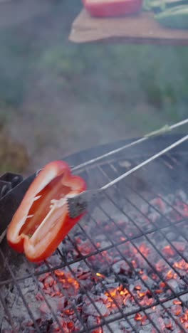 man grilling bell peppers outdoors