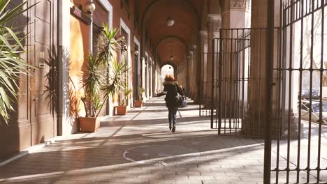 portrait of young woman runs under the arches in the city