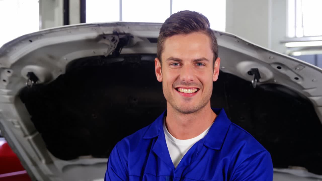 mecánico de pie en el taller de reparación con llave inglesa